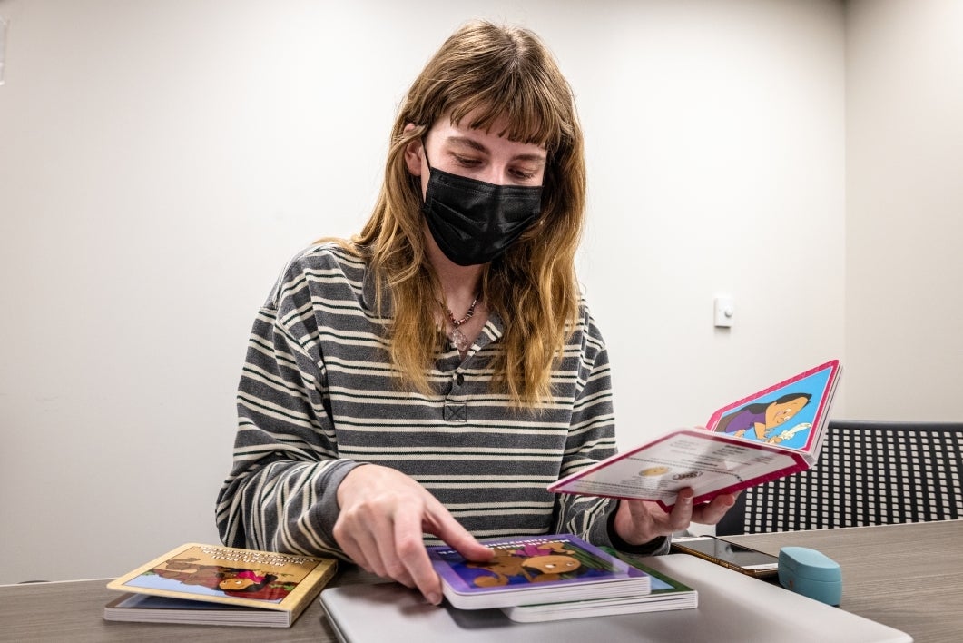 student looking at Indigenous children's picture books